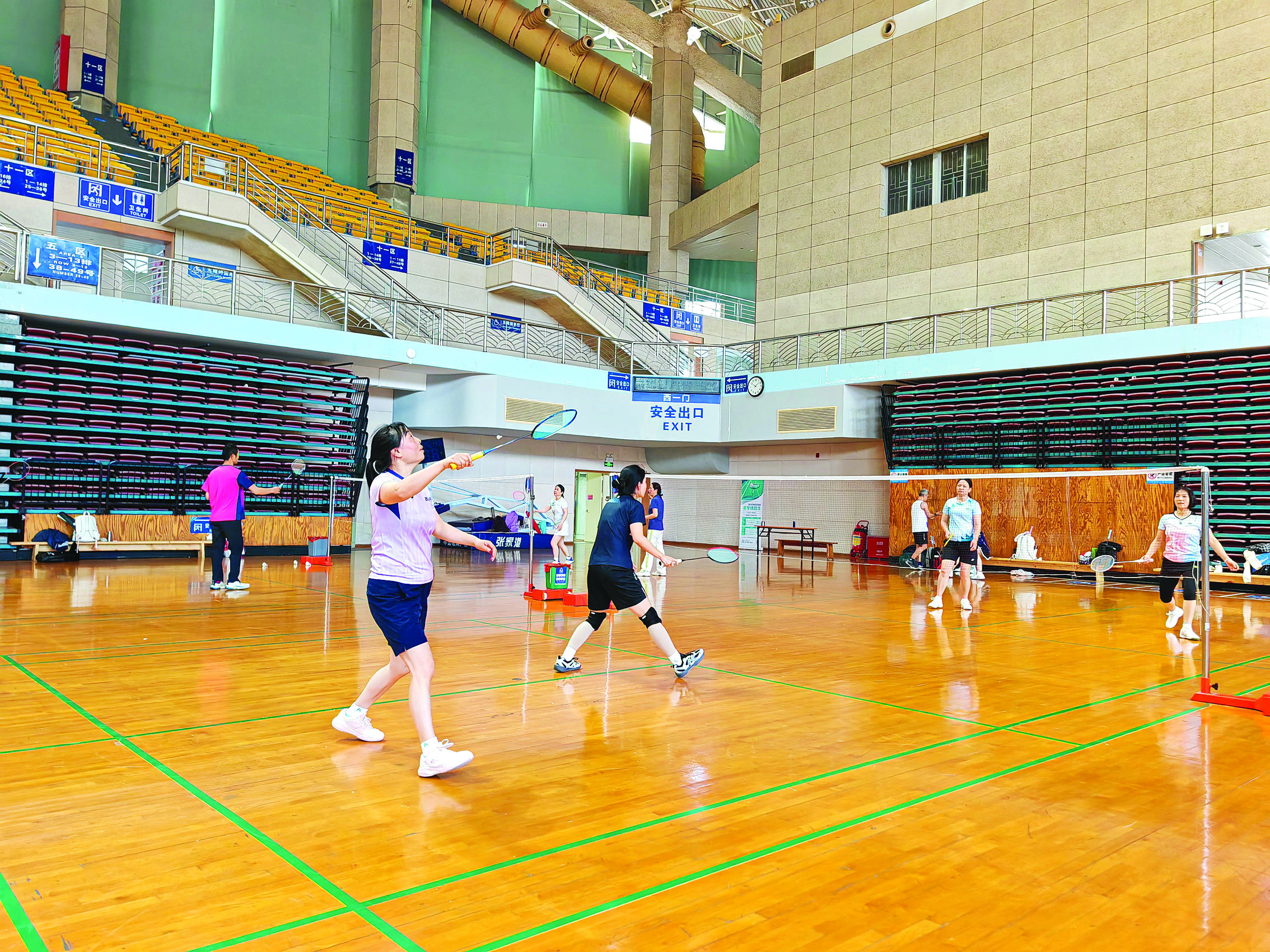     市民在体育馆打羽毛球。