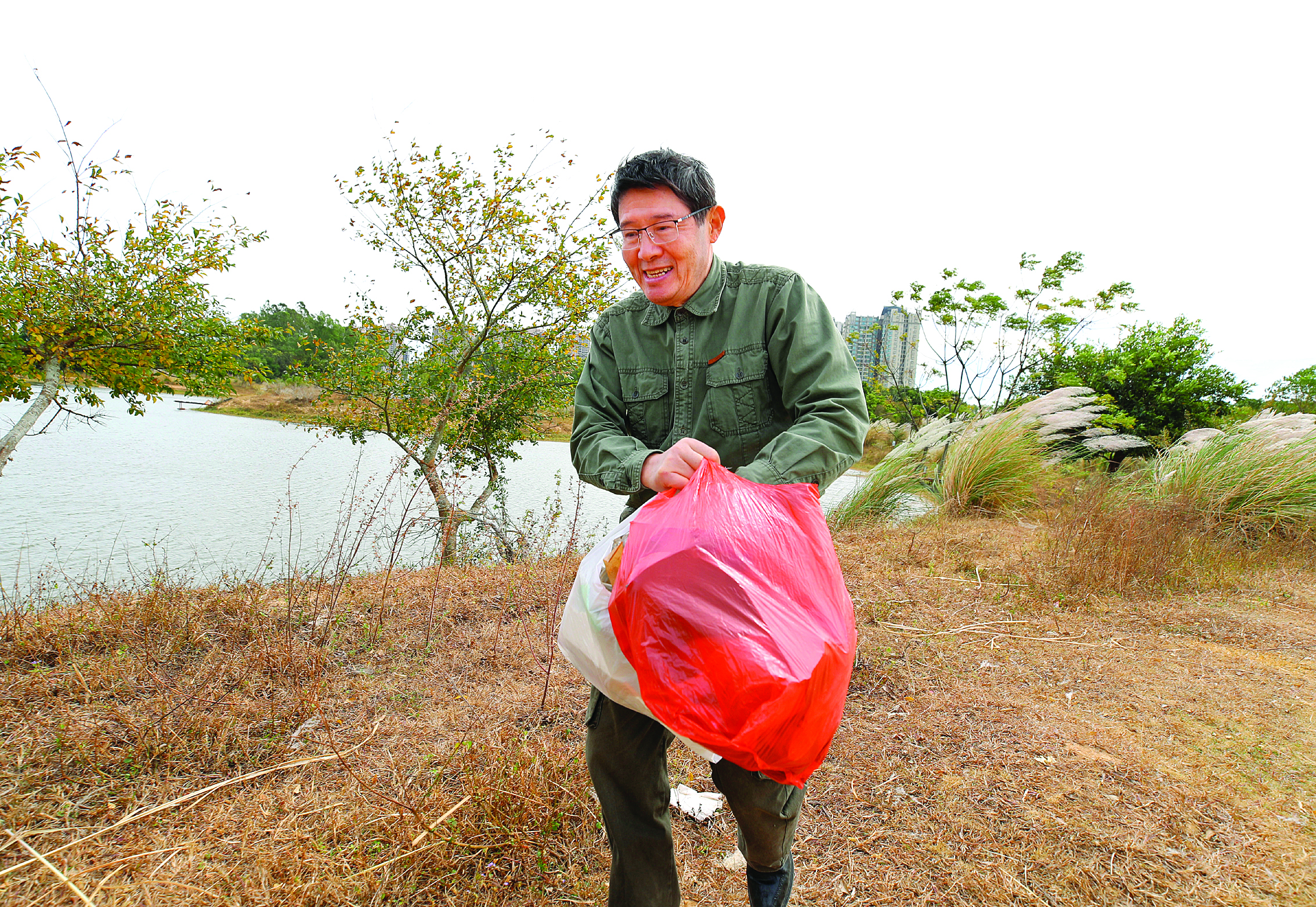     芮和在东江边拾捡垃圾。 惠州日报记者钟畅新 摄