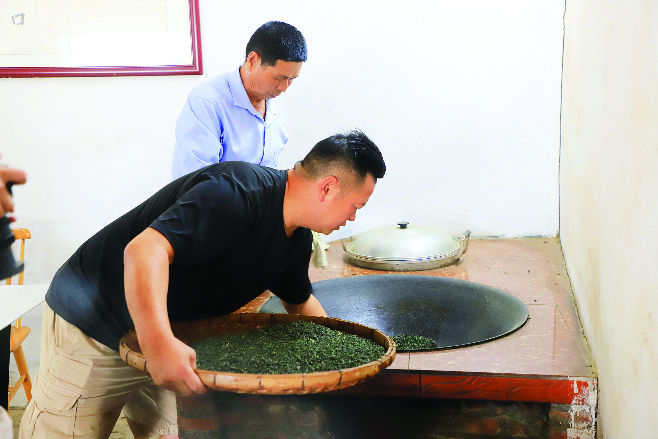     曾桂锦、曾荣华父子在炒茶。