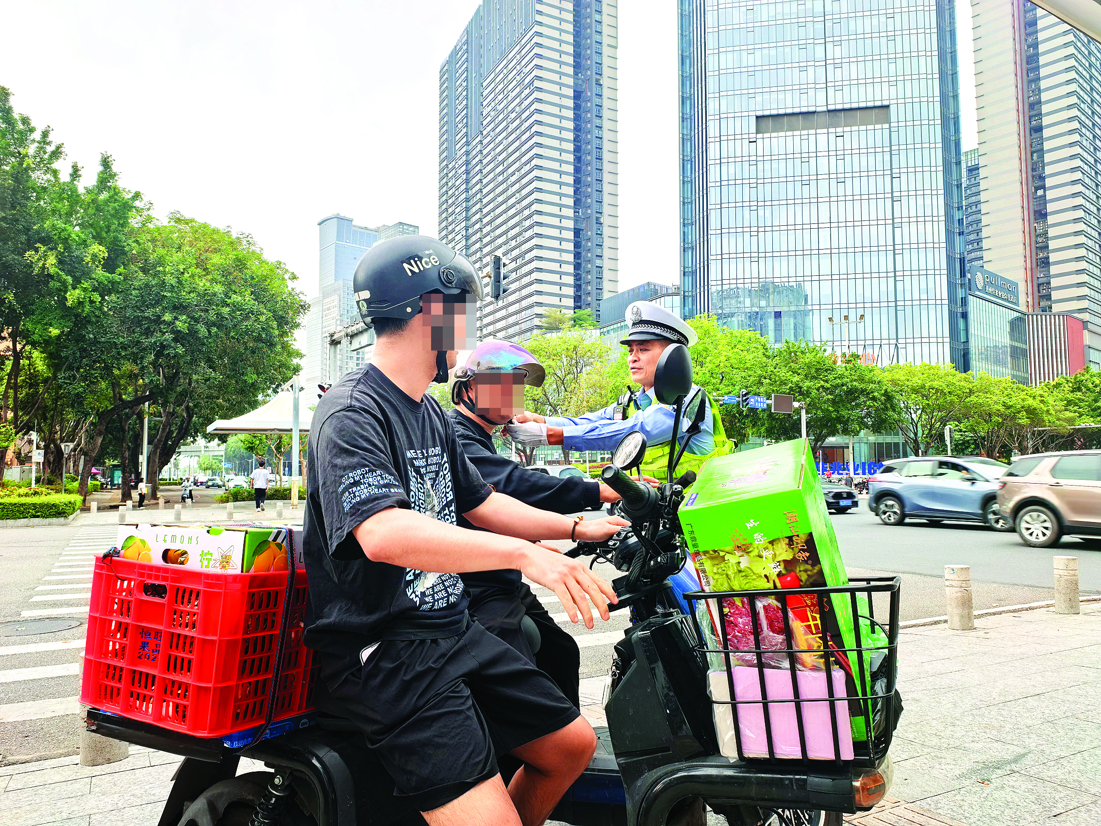     惠州交警为市民扣好头盔卡扣。惠州日报记者刘豪伟 摄