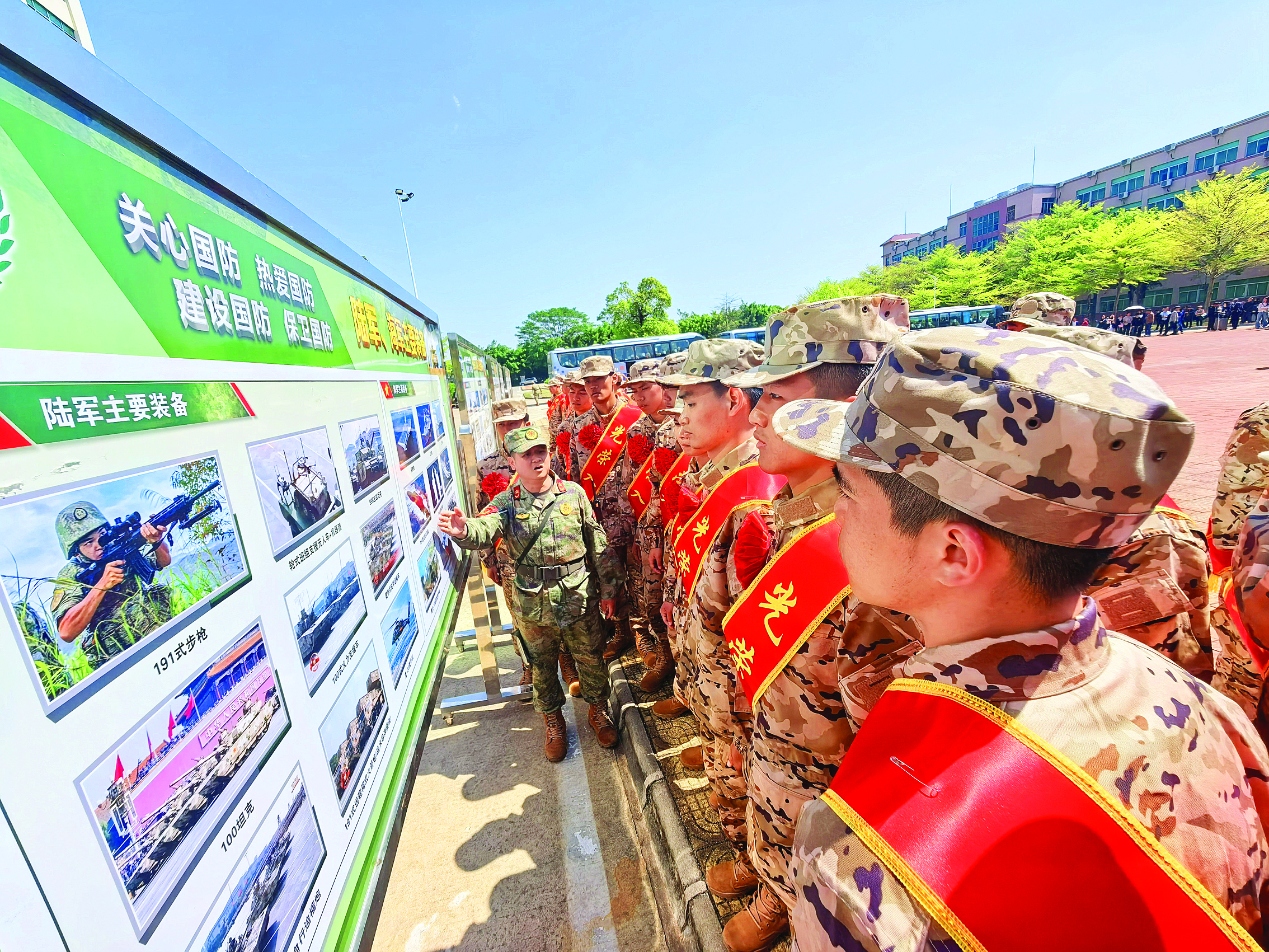     新兵们正在集中观看“全民国防教育”主题展板，直观了解我国国防和军队建设成就。