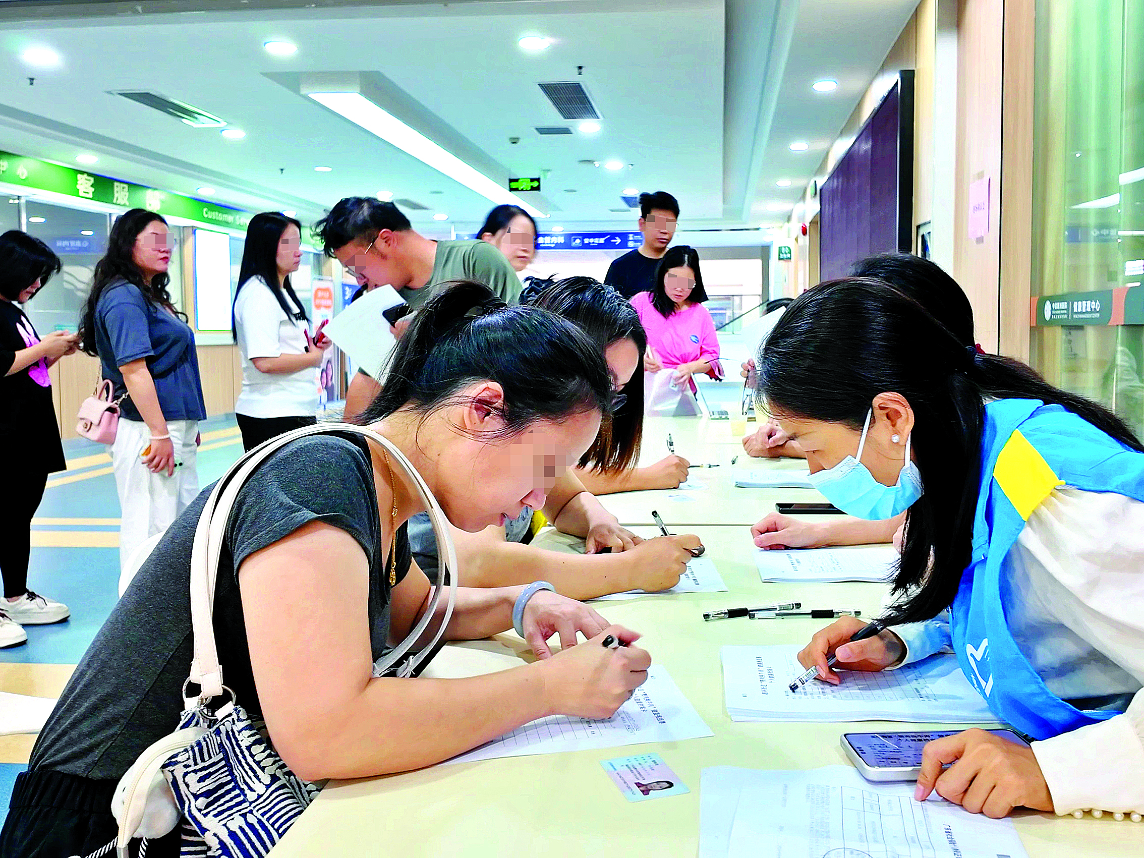     报名者在工作人员指引下填写表格。