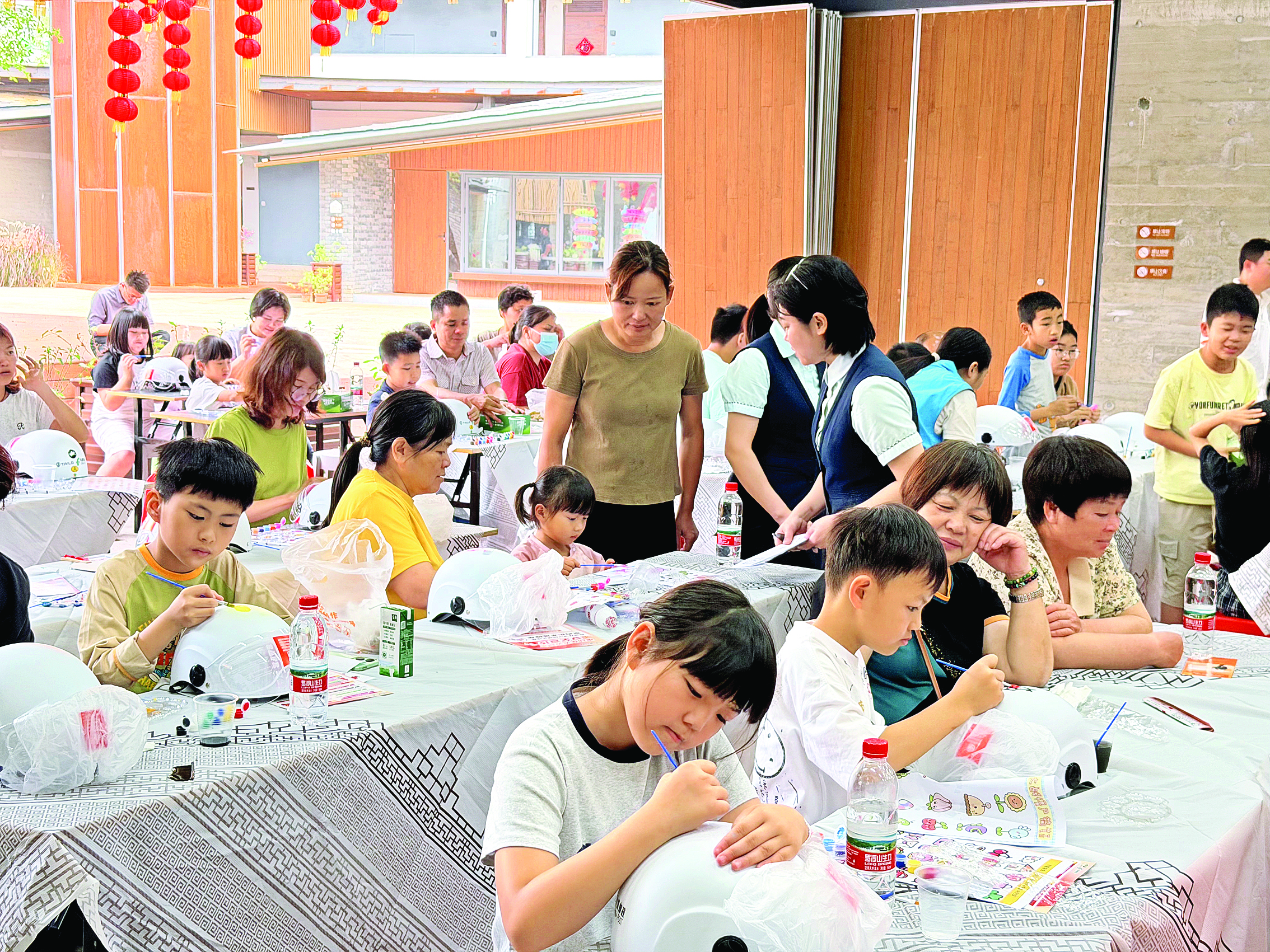     孩子们在白色头盔上尽情创作。  惠州日报记者李燕文 通讯员长宁宣 摄