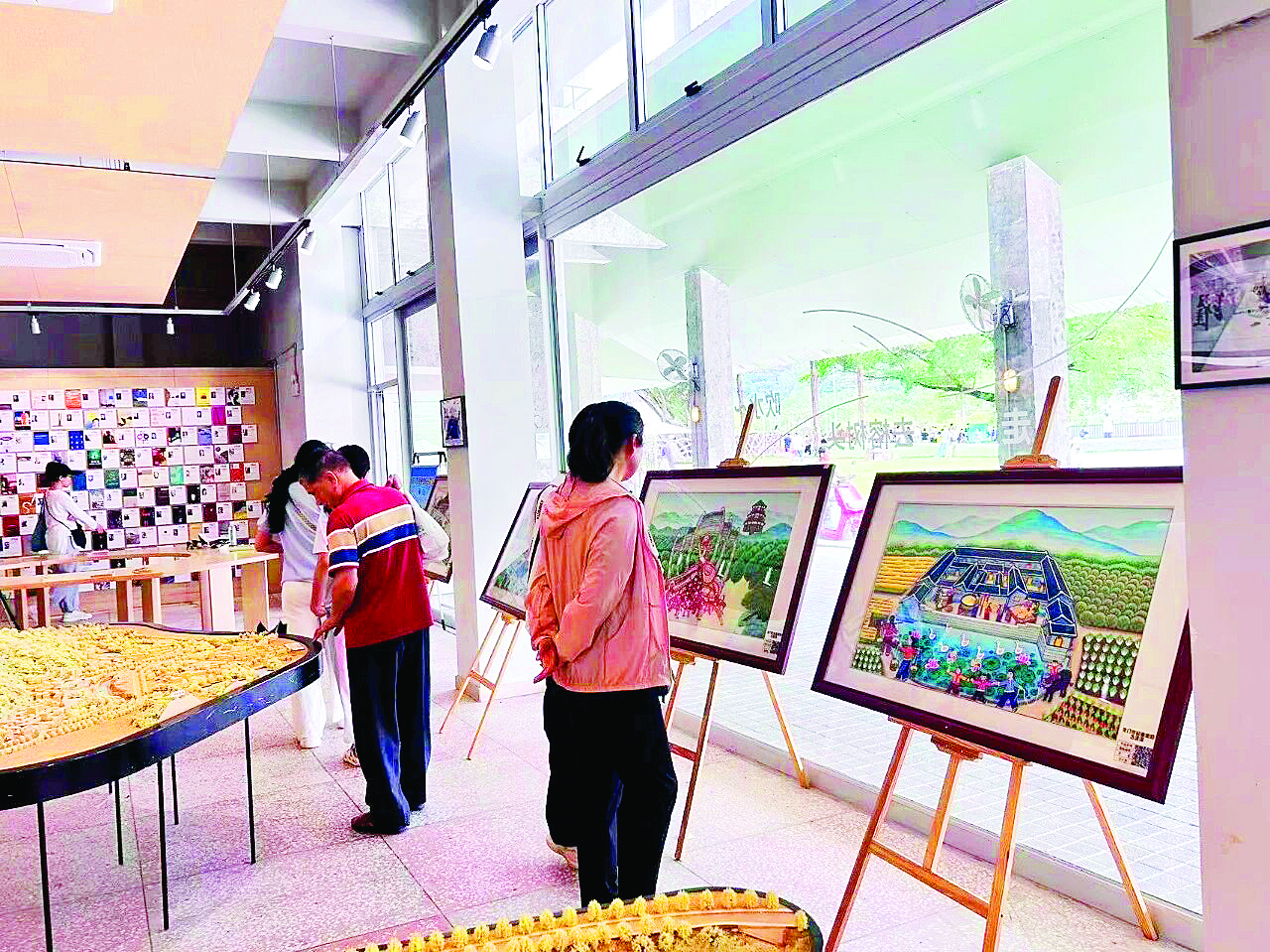     游客在在千年古榕驿站粮仓书局内欣赏龙门农民画画作。    惠州日报记者黄宇翔 通讯员龙融心 摄