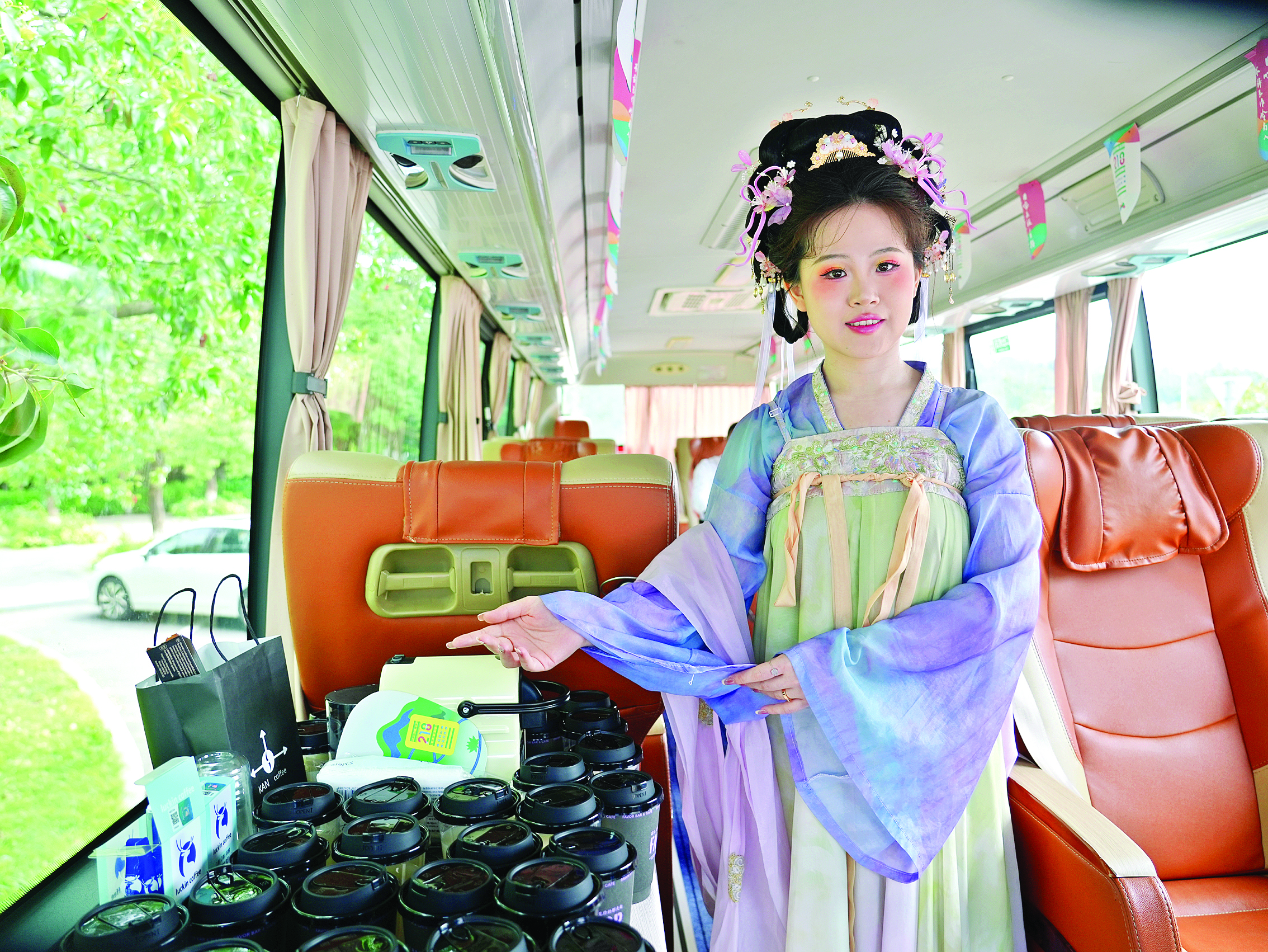     观光巴士上，工作人员身着特色服饰为乘客提供茶饮等服务。    图片由博罗宣提供