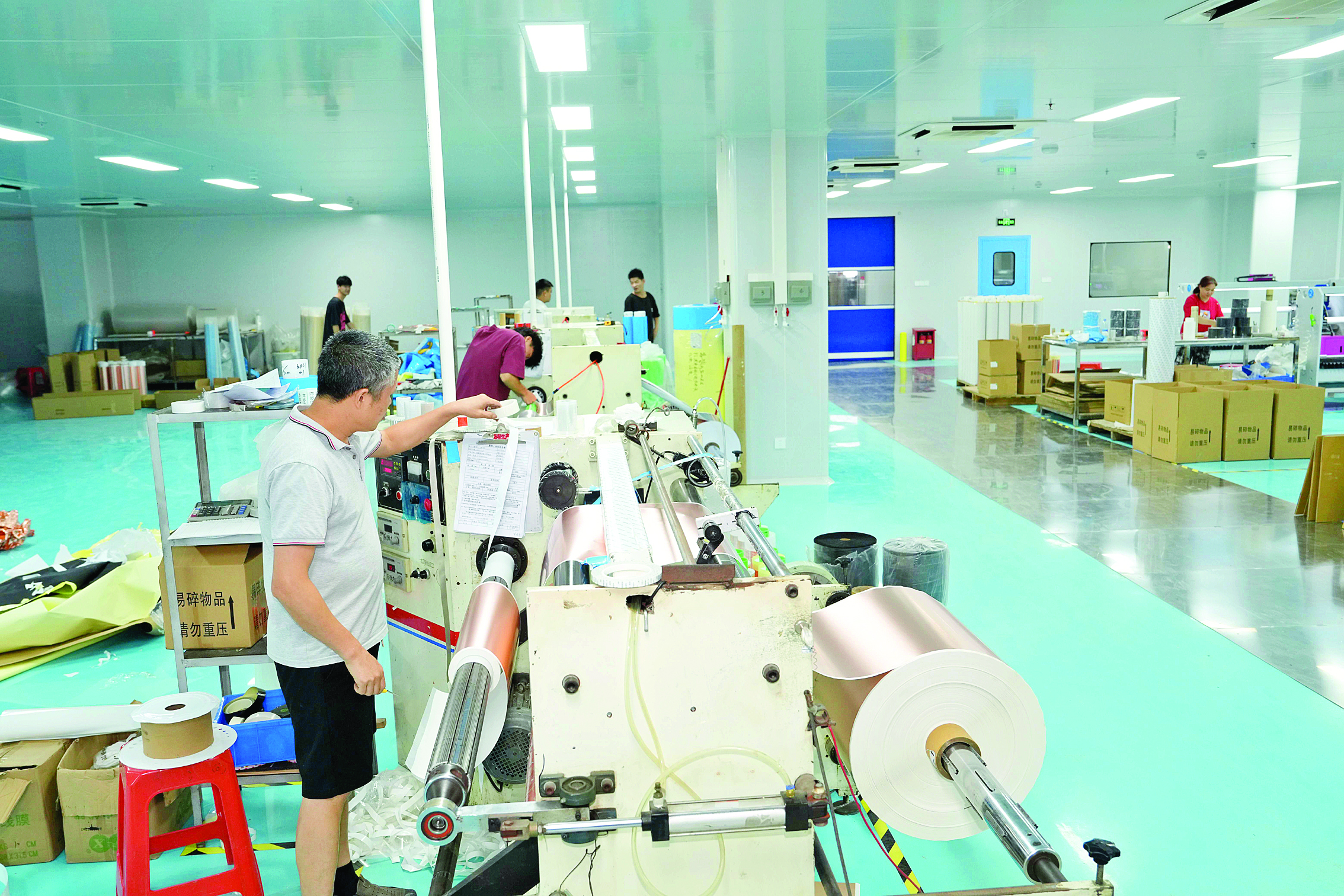     在园区一功能膜生产企业里，工人正在检查薄膜生产情况。
