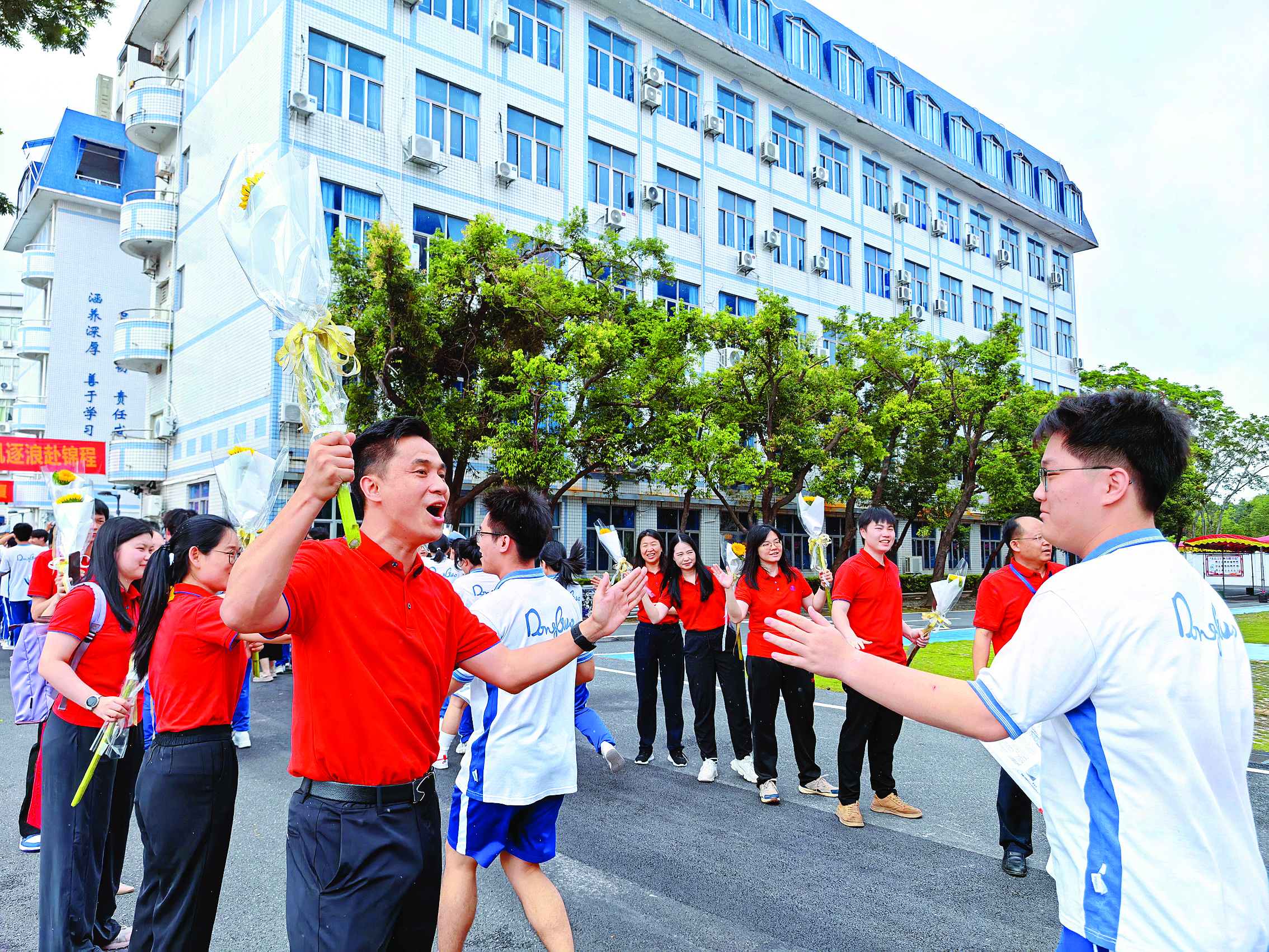     在惠州市东江高级中学，学校老师身穿红色衣服为考生加油鼓劲。惠州日报记者叶丽莎 通讯员张斌 摄