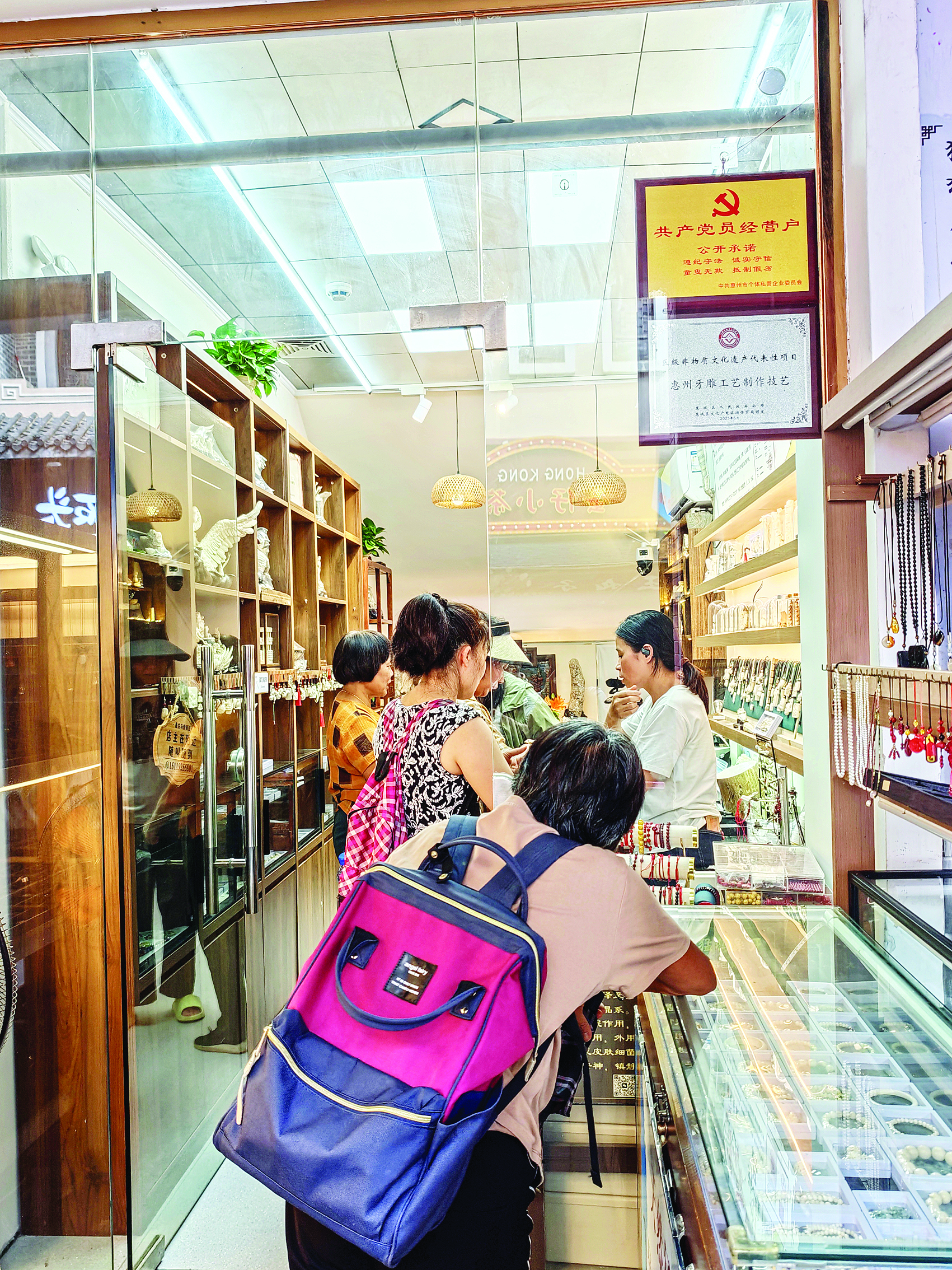     水东街一家商铺门口挂着“共产党员经营户”牌匾。    惠州日报记者香金群 摄